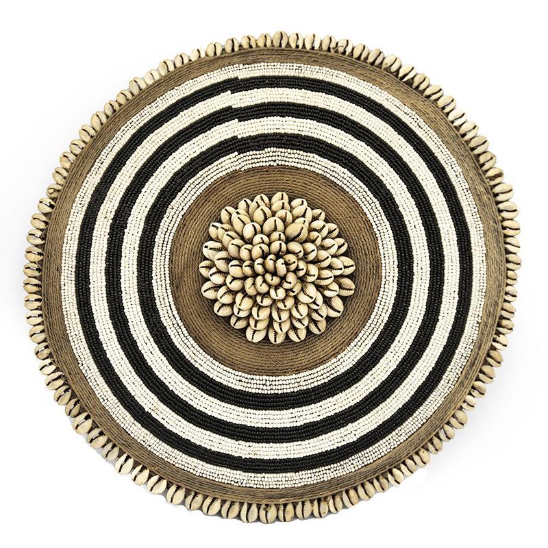 Round woven mat with concentric circles of black, white, and brown on a white background