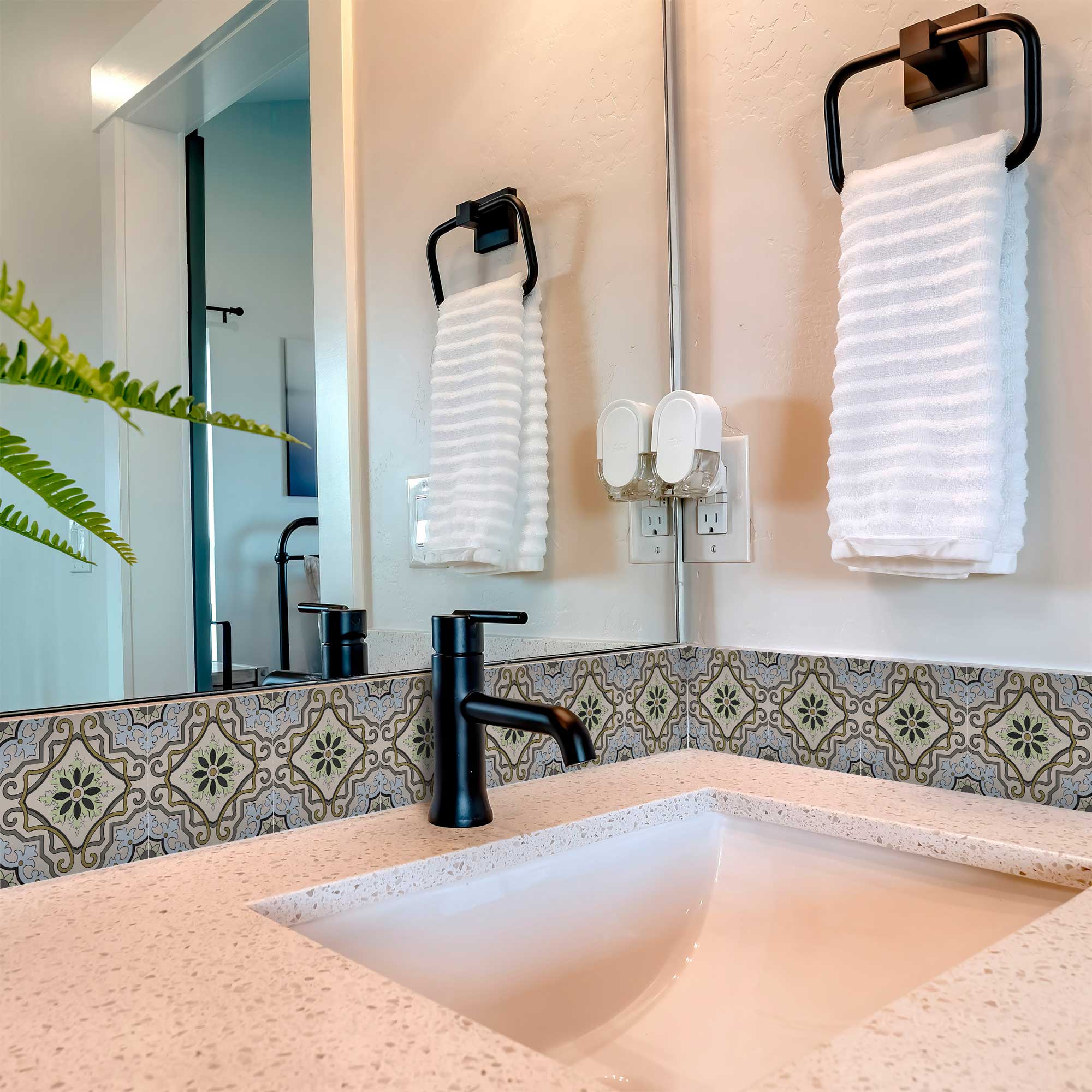 Bathroom sink with black faucet, mirror, and white towels.