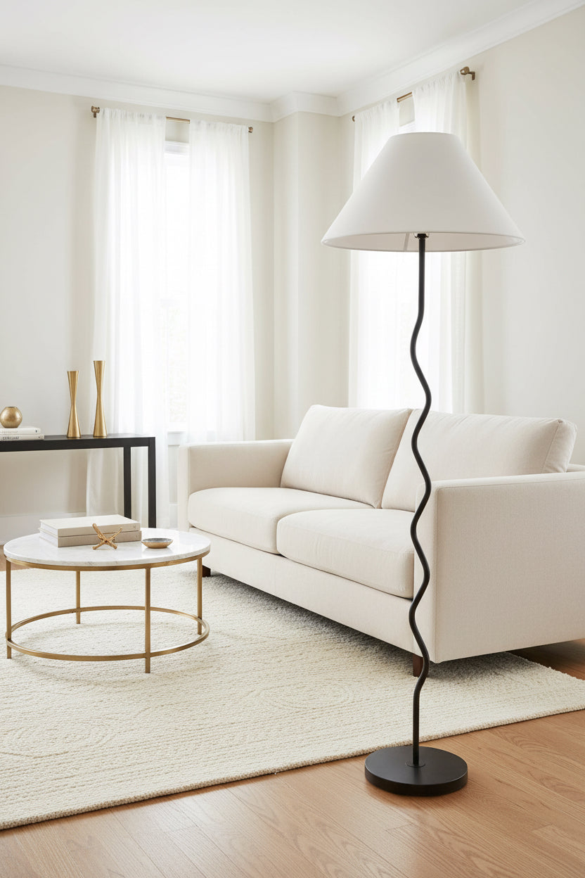 Floor lamp with a white shade and black curved base on a white background