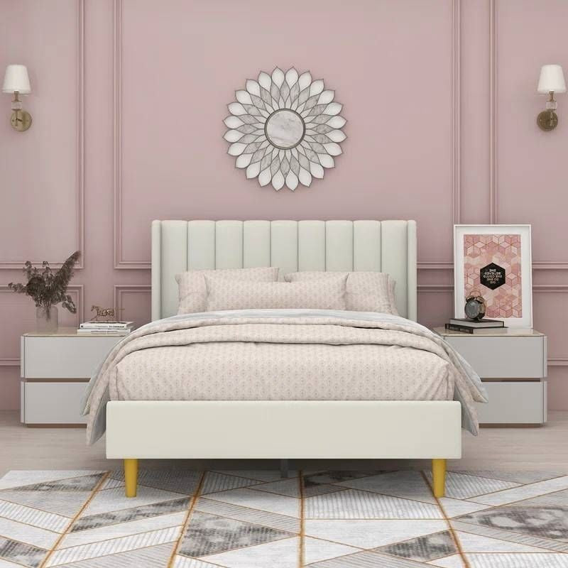 Neatly made bed in a bedroom with pink walls and decorative elements.