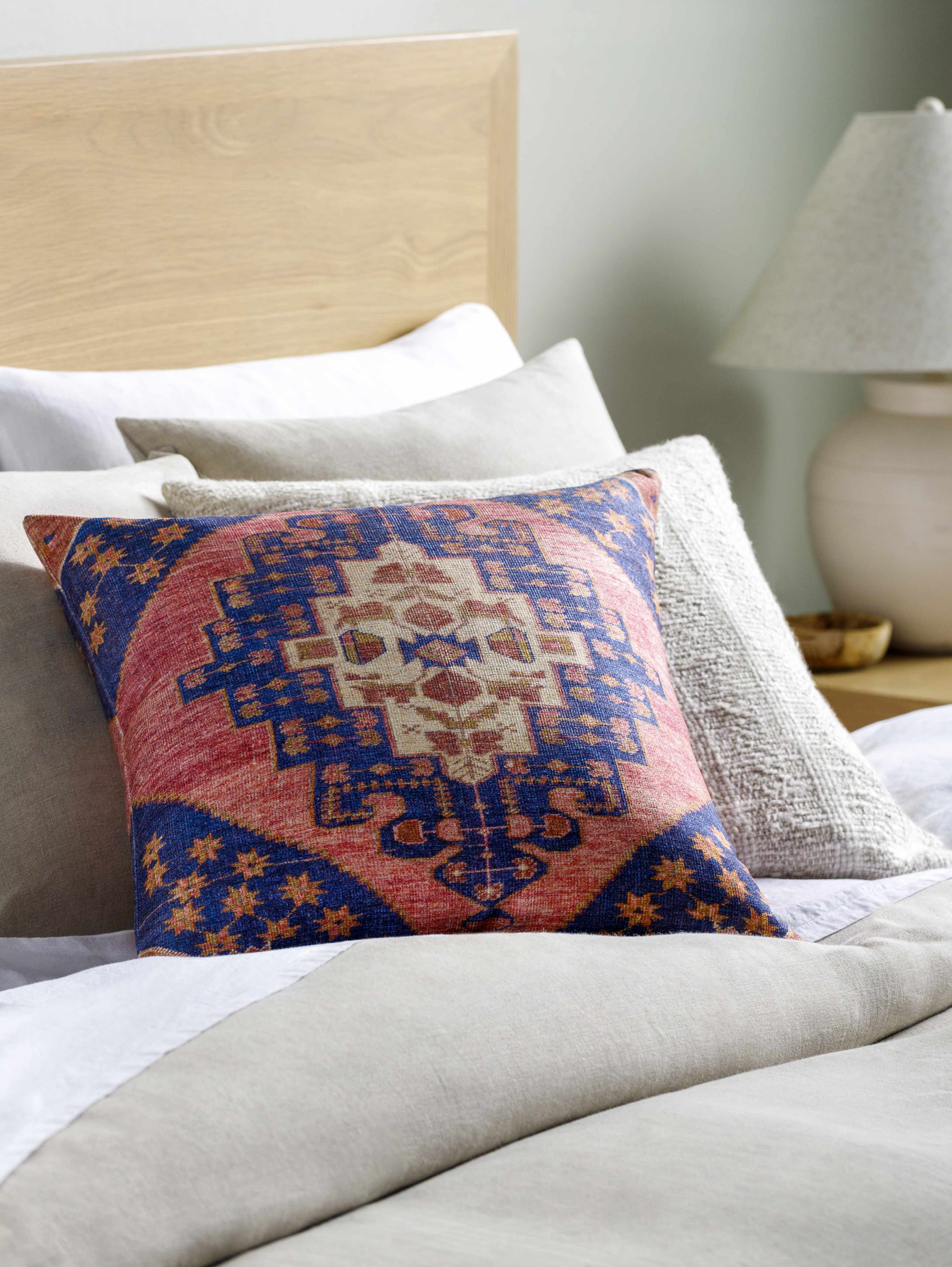 Decorative pillow with geometric pattern on a bed in a bedroom setting