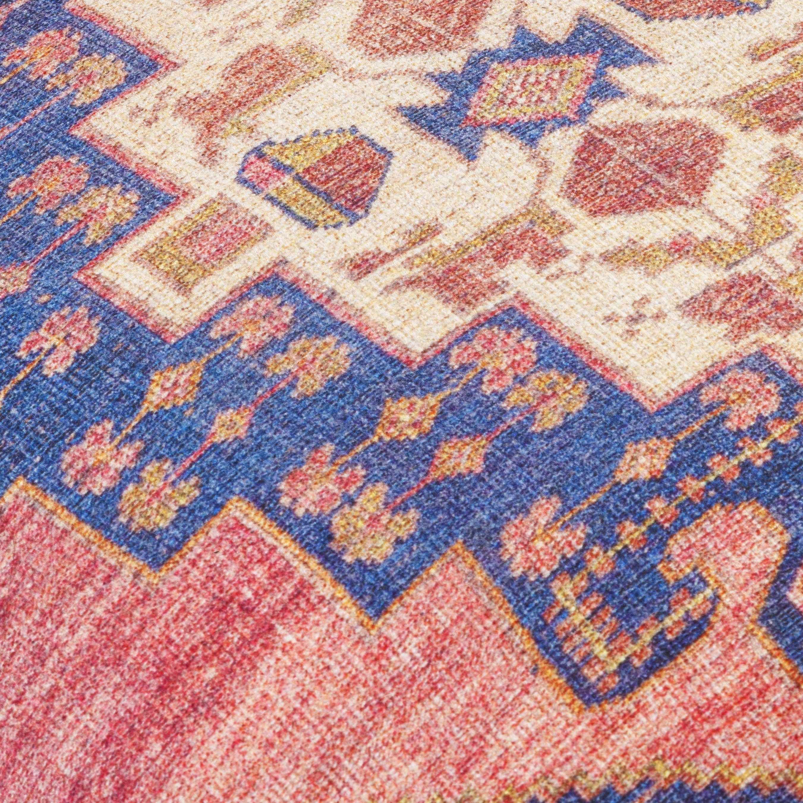 Close-up of a patterned rug with red, blue, and beige colors.