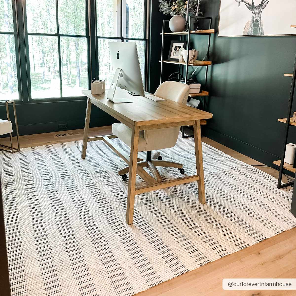 Home office with wooden desk, chair, and large windows.