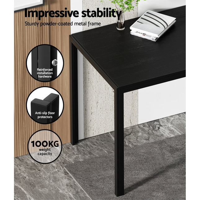 Black desk with stability features highlighted on a gray floor.