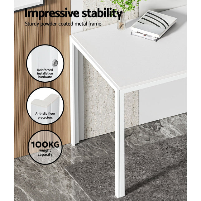 White office desk with stability features highlighted on a gray floor.