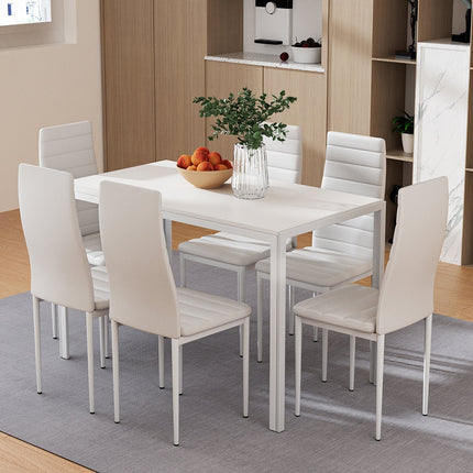 Dining room with a white table and chairs, fruit bowl, and plant.