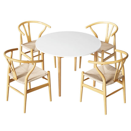 Round white table with four wooden chairs on a white background