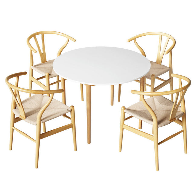 Round white table with four wooden chairs on a white background