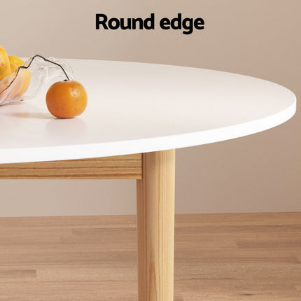 Round edge table with a glass bowl of lemons and an orange on a wooden floor.