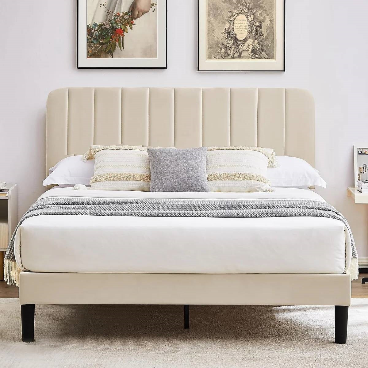 Beige upholstered bed with pillows and a blanket in a bedroom setting.