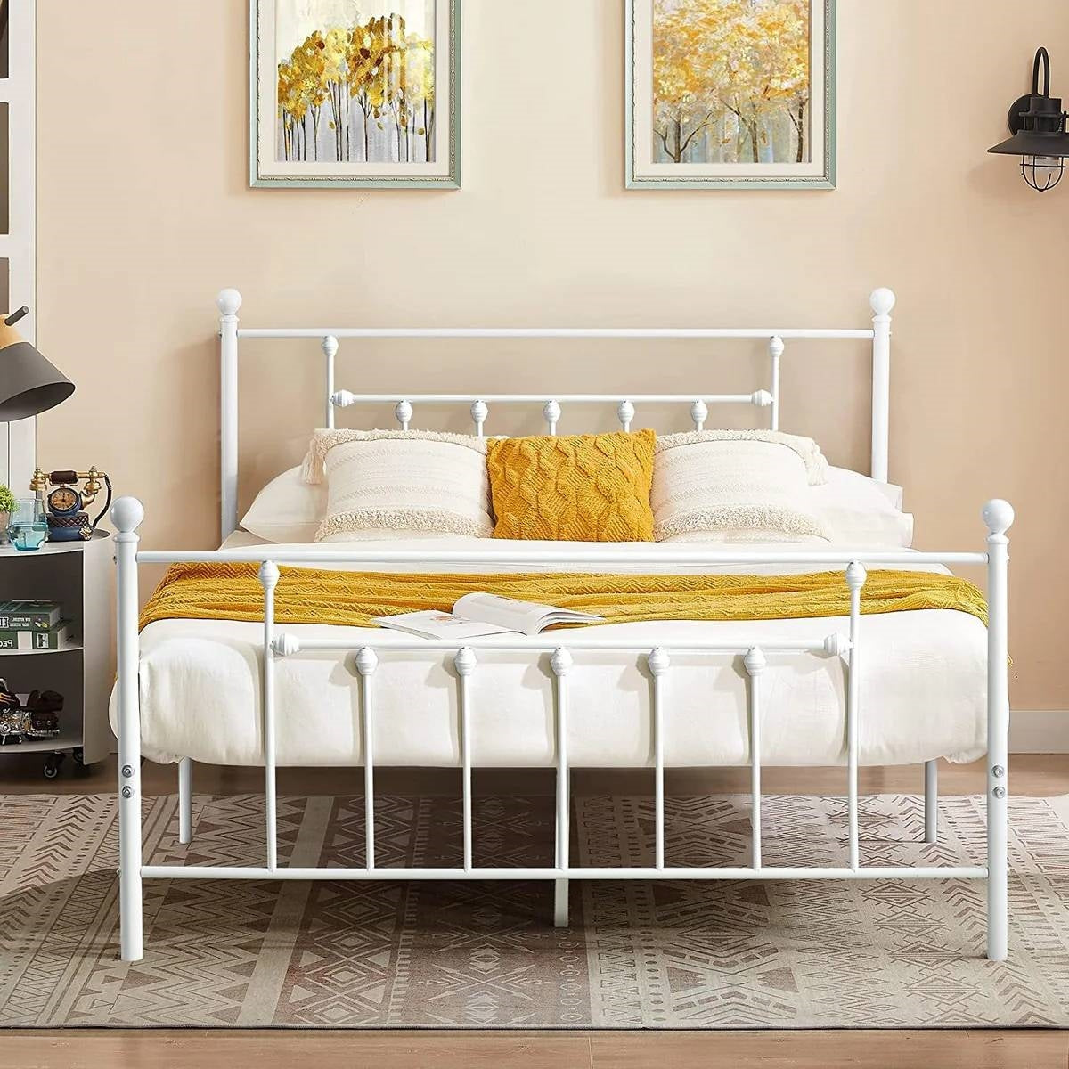 White metal bed with yellow bedding in a bedroom setting