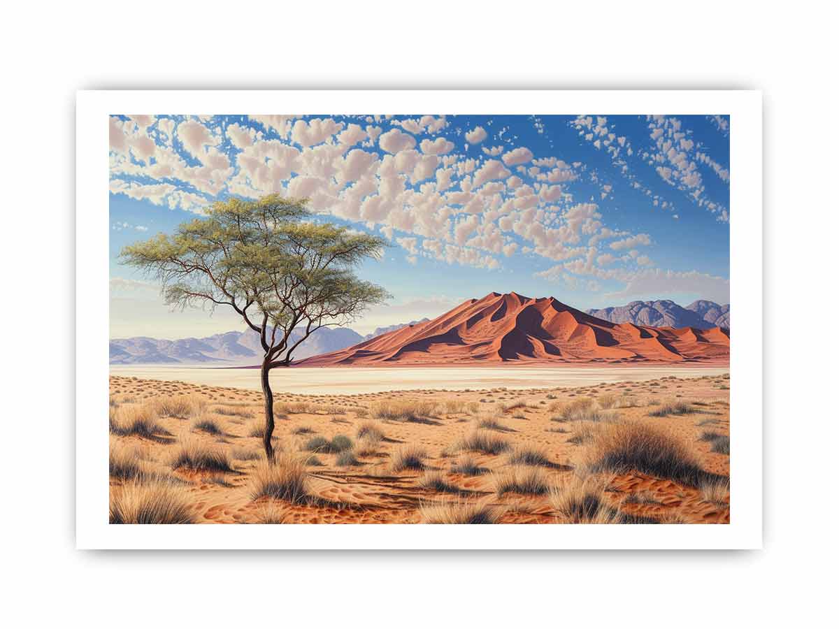 Desert landscape with a lone tree and red sand dunes under a blue sky with clouds.