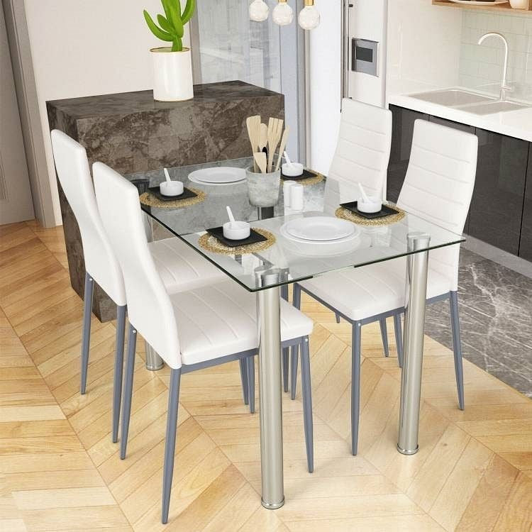 Dining table with glass top and metal legs in a modern kitchen setting
