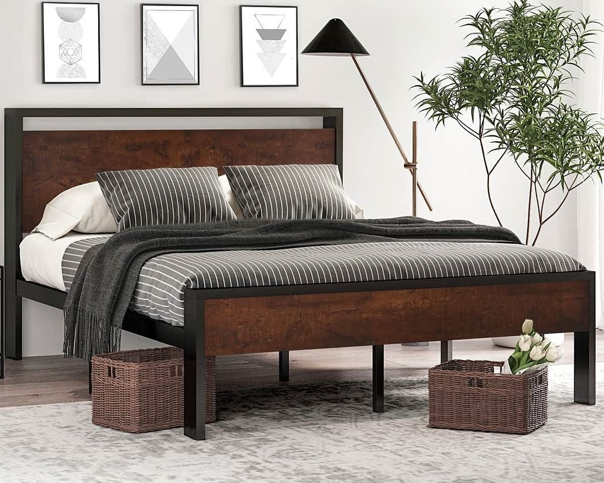 Wooden bed frame with bedding in a bedroom setting with decor elements.