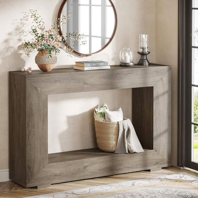 Wooden console table with decorative items in a room with a mirror and window.