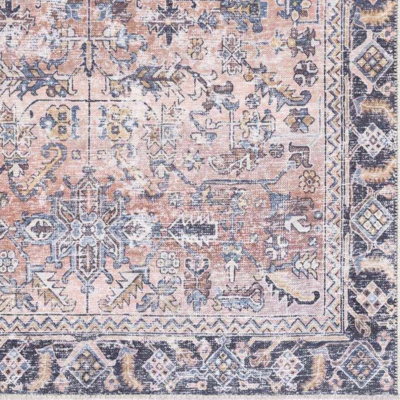 Close-up of a patterned rug with a mix of colors including pink, blue, and beige.