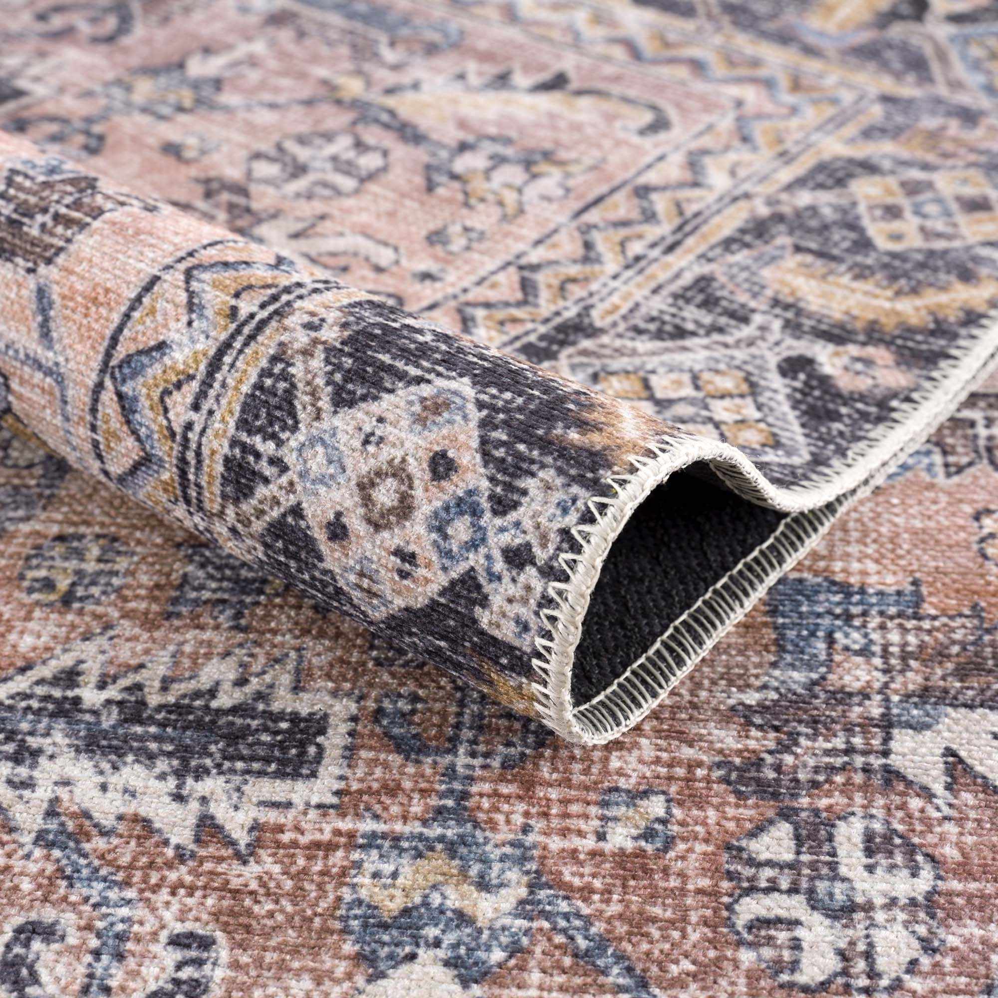 Close-up of a patterned rug with a rolled-up section showing the texture and design.