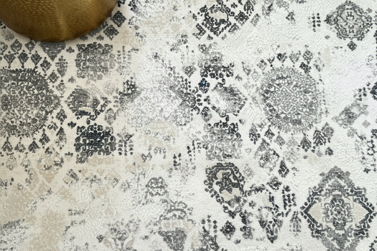 Person holding a cup of coffee with feet in sandals on a patterned rug