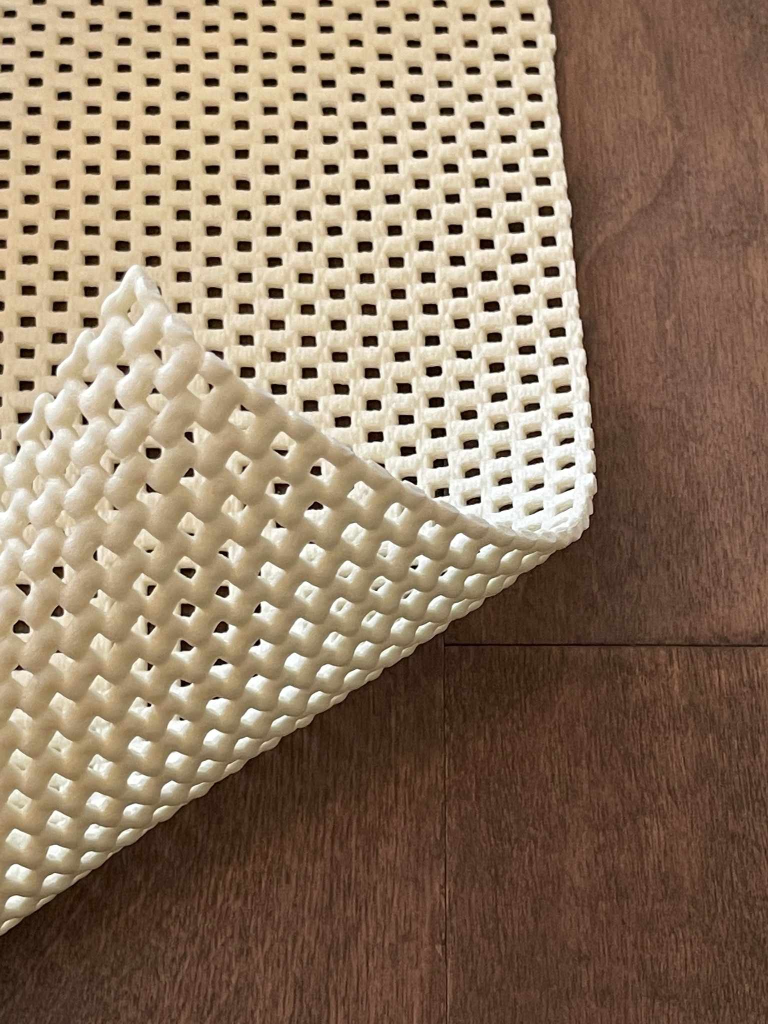 Close-up of a textured beige rug on a wooden floor