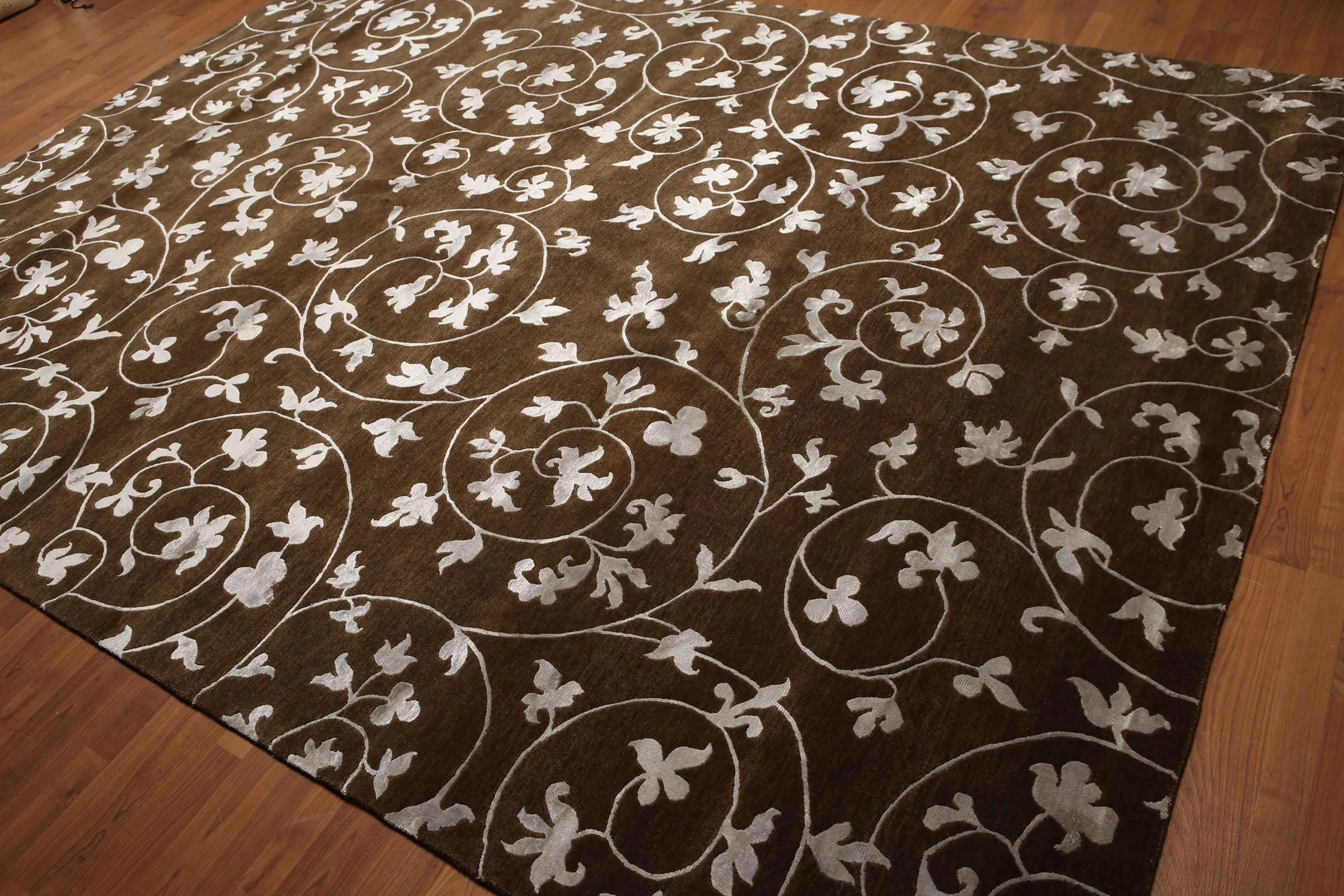 Brown rug with white floral patterns on a wooden floor