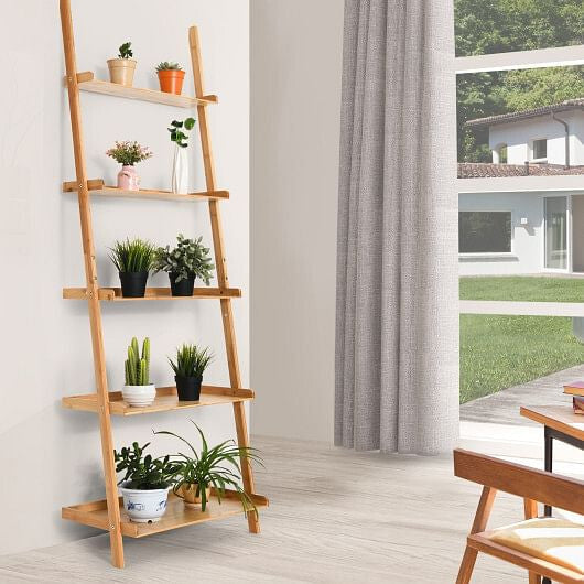 Leaning ladder shelf with plants in a room with a large window.