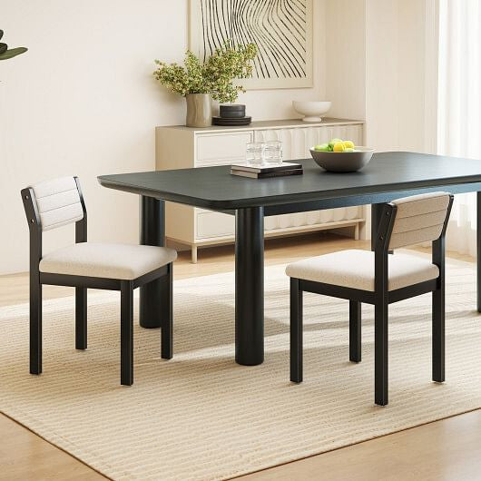 Dining room with a black table and white cushioned chairs on a beige rug.
