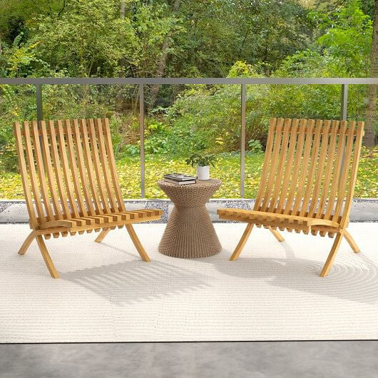Two wooden chairs with a small table on a deck with a forest background