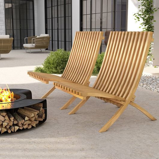 Two wooden lounge chairs by a fire pit on a patio