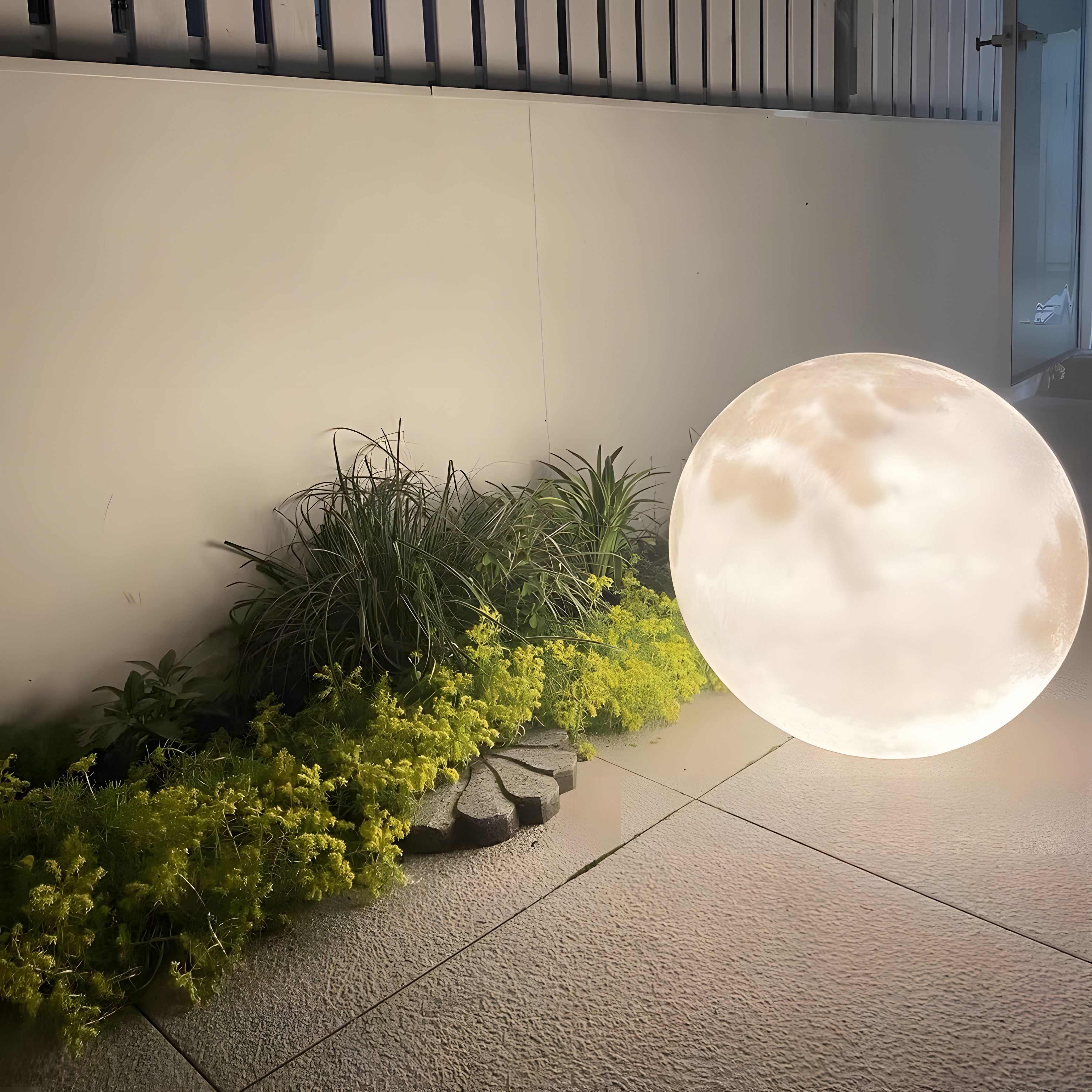 Round garden light fixture on a patio with plants and a wall in the background