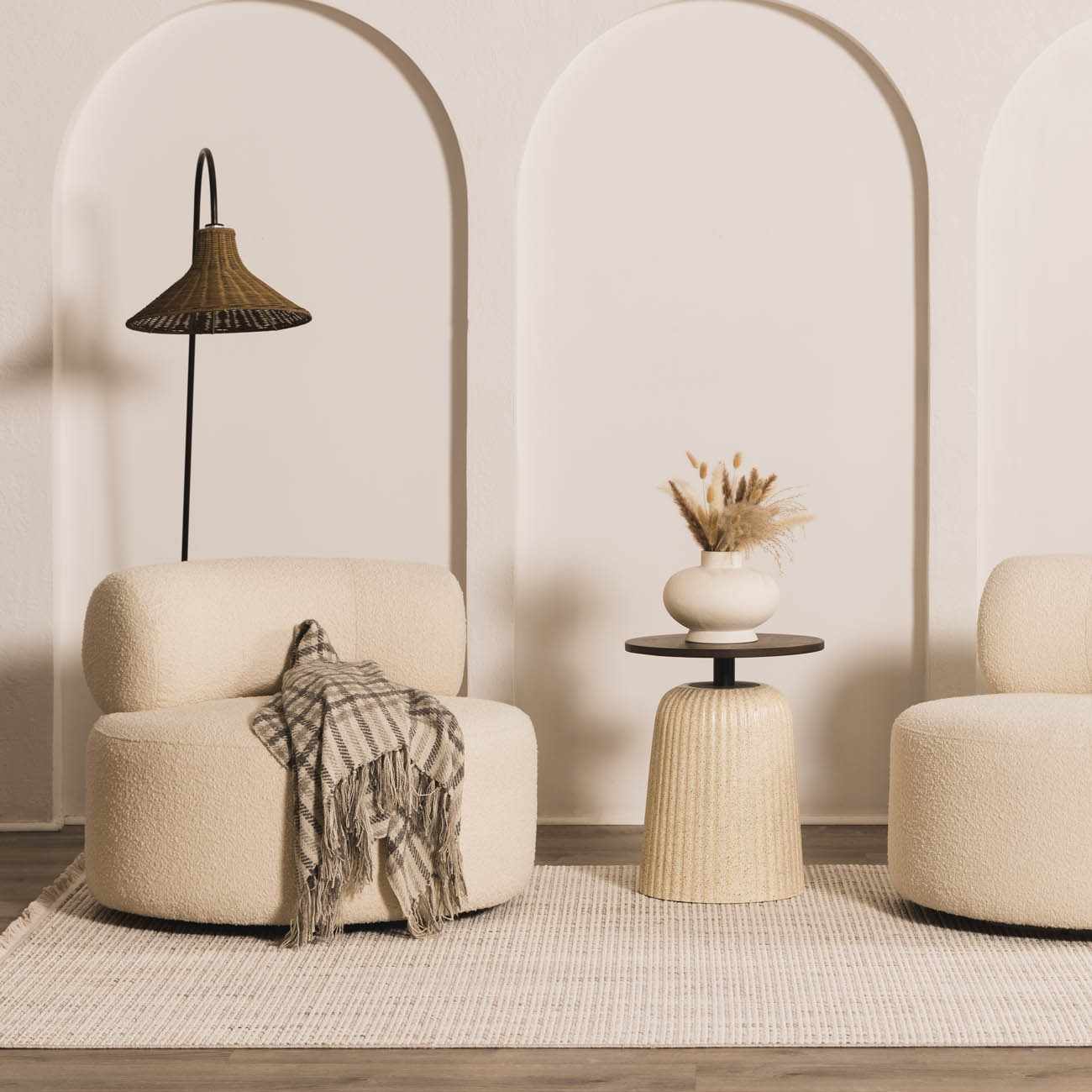 Modern interior with beige armchairs, a side table, and decorative elements.