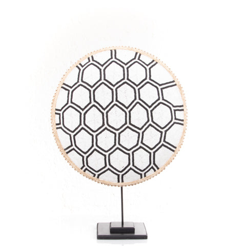Decorative plate with geometric pattern on a stand against a white background