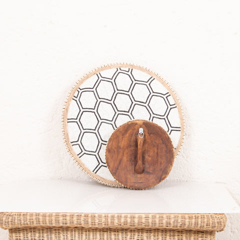 Wooden disc with a hexagonal pattern on a white background