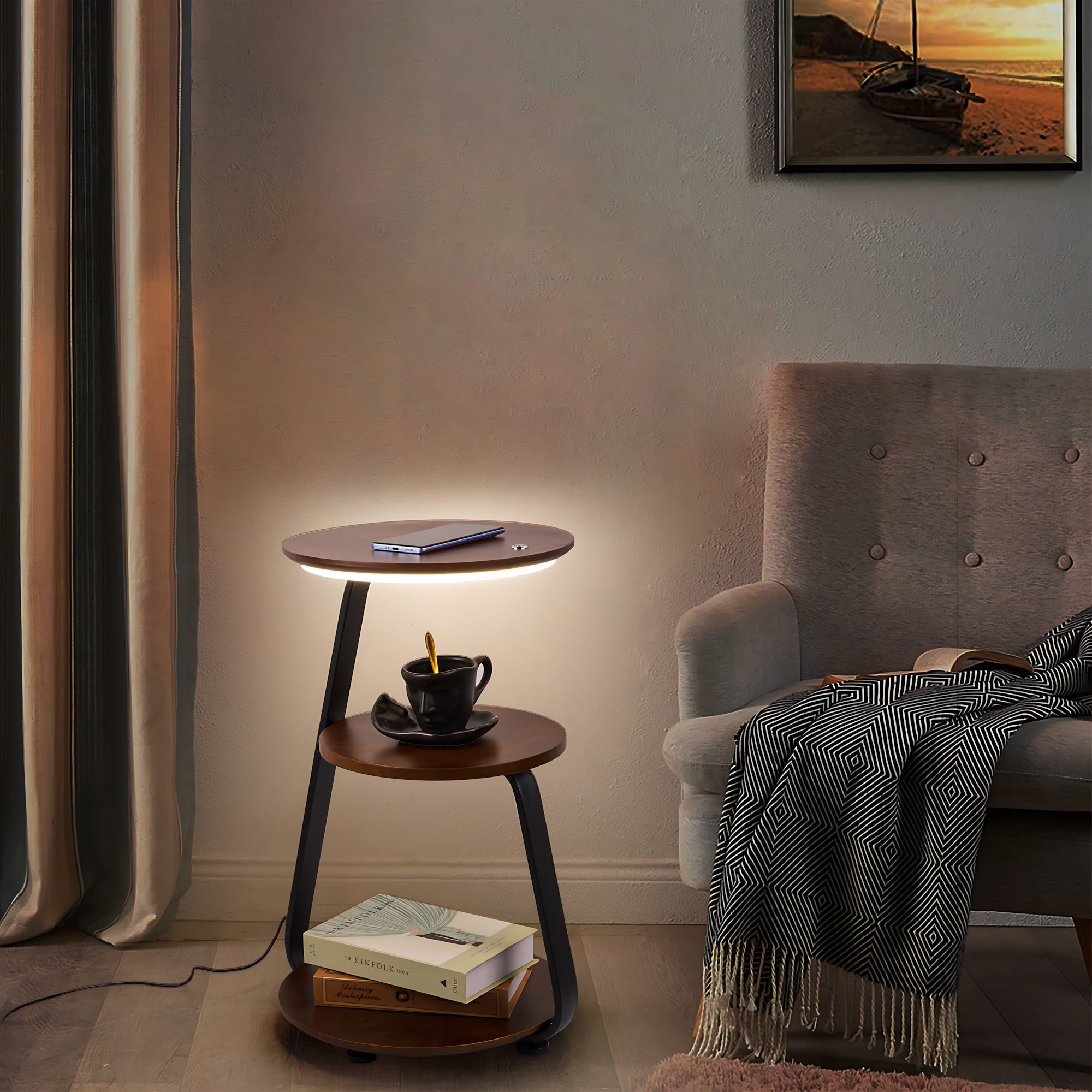Small round wooden side table with a lamp next to a gray armchair in a cozy room.