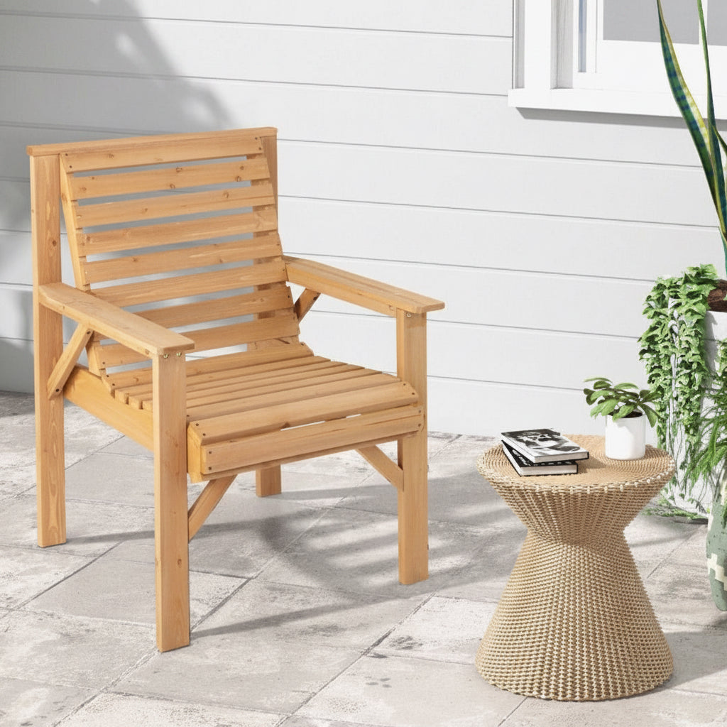 Wooden chair and woven side table on a patio with a white wall background