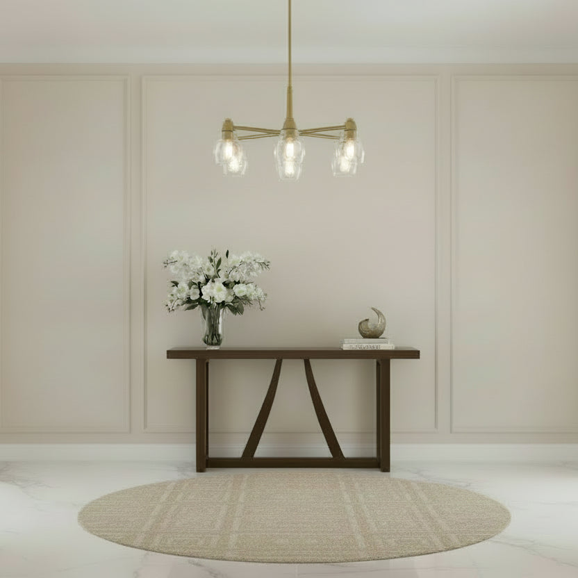 Brass pendant light fixture with clear glass shades on a white background