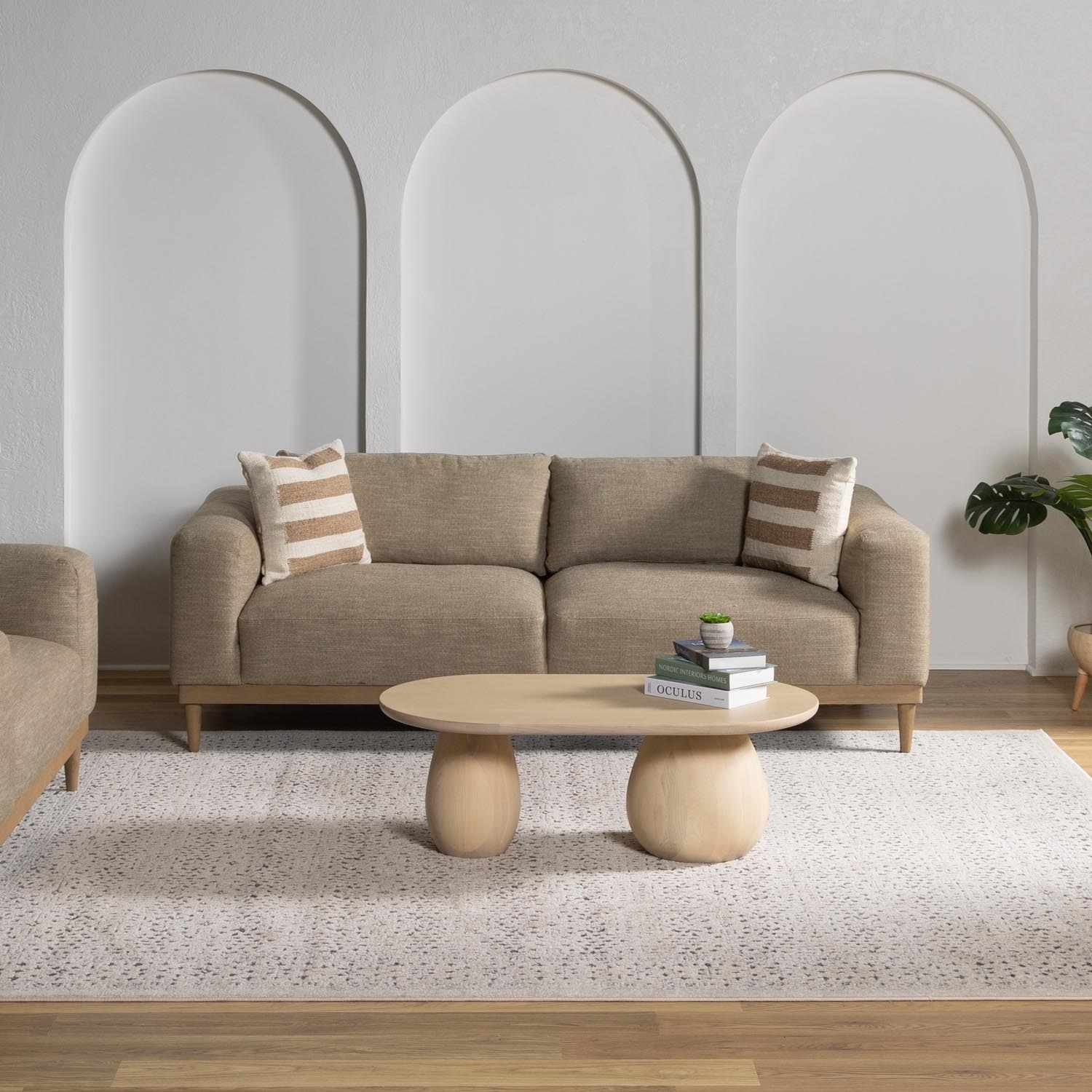 Beige sofa with striped cushions in a modern living room setting.