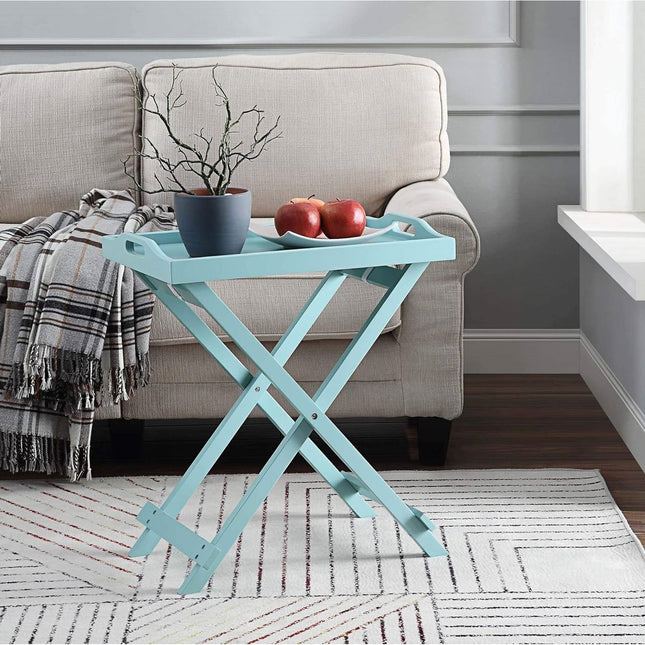 Light blue folding side table with a plant and apples in a living room setting.