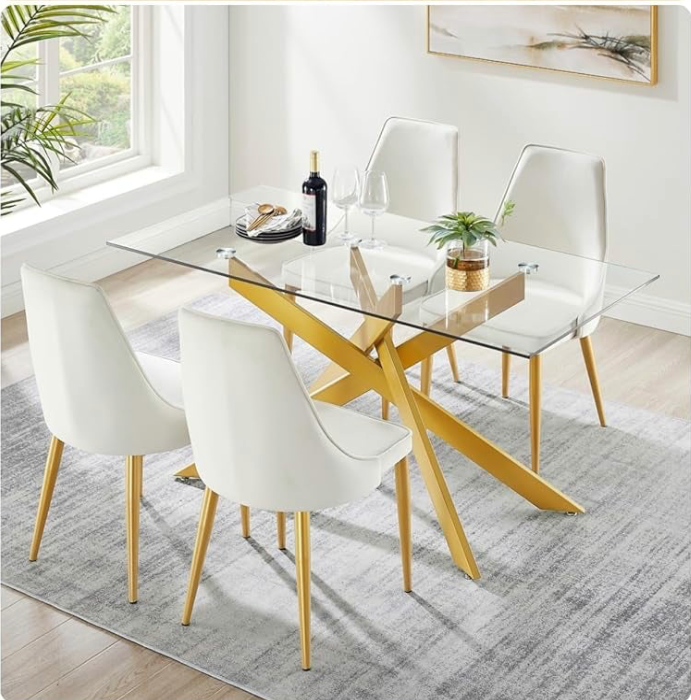 Dining room with a glass table and white chairs with gold legs.