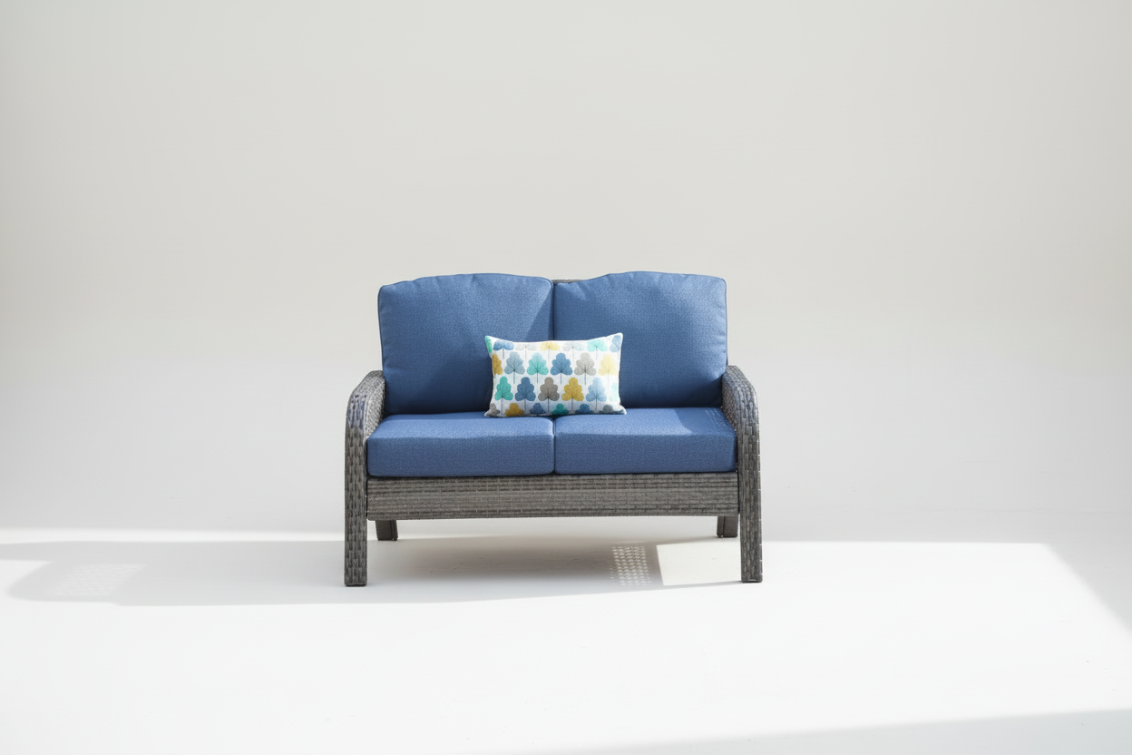 Outdoor patio set with blue cushions, a small table with drinks, and a decorative pillow.