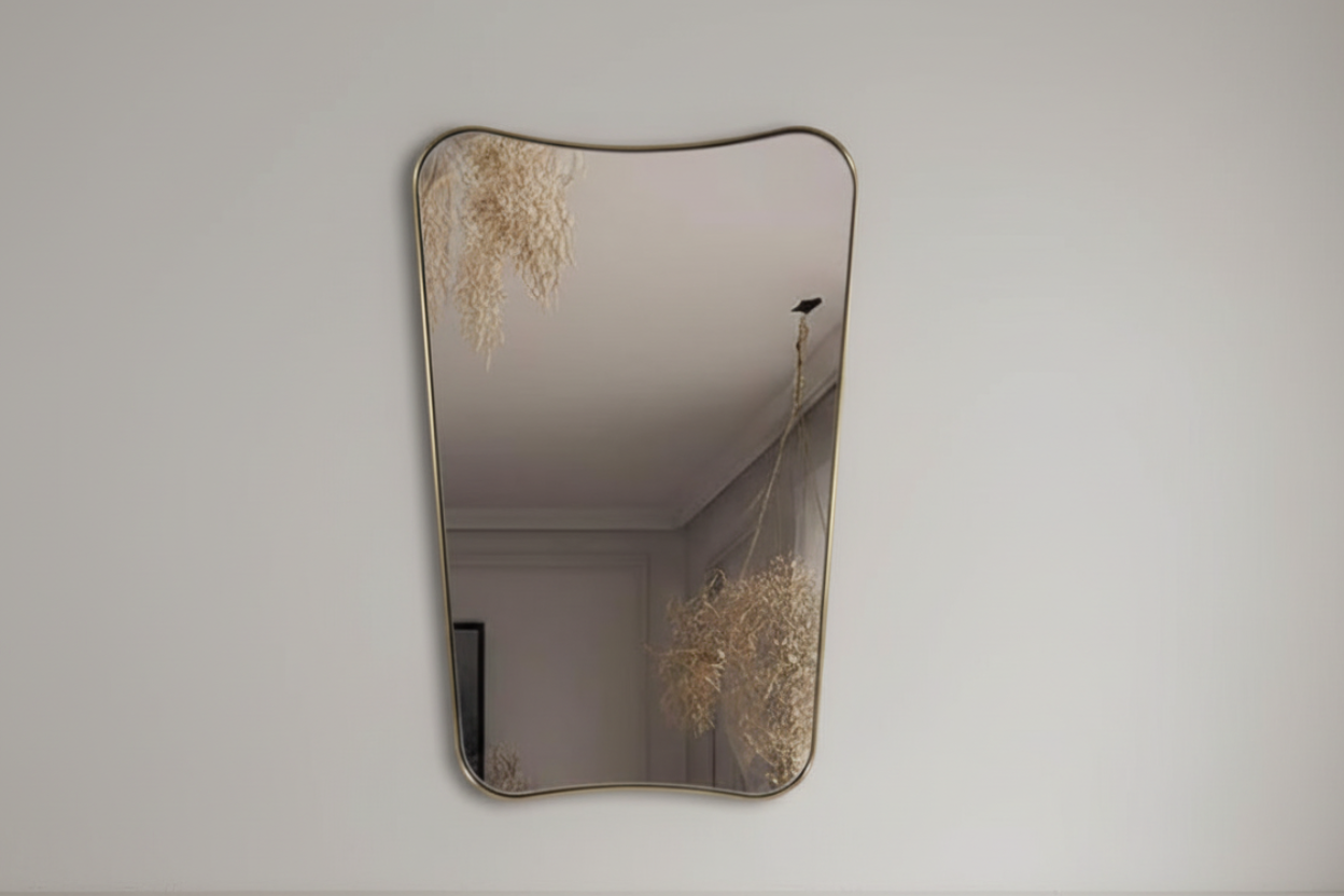 Decorative wall mirror with a textured frame on a plain wall