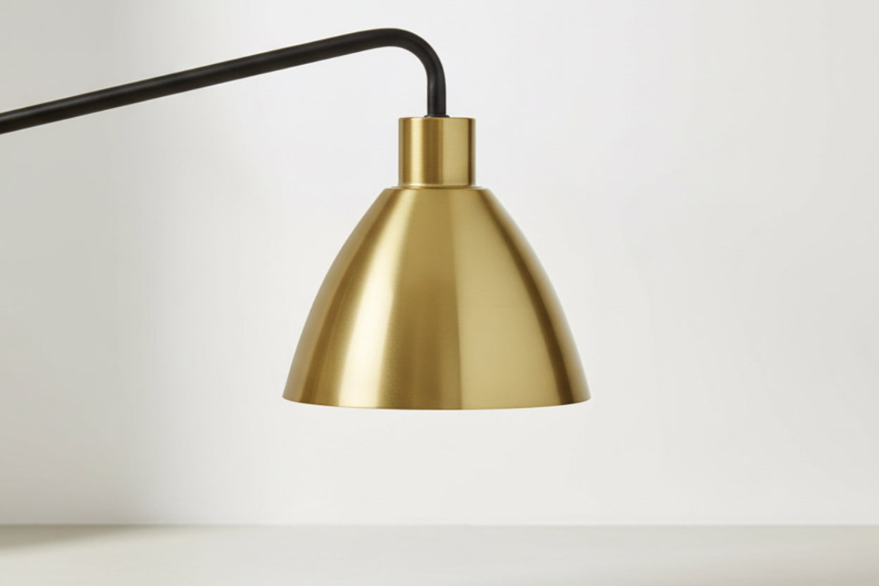Gold lampshade with black cord on a white background