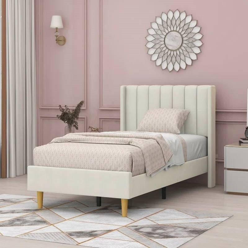 Beige upholstered bed in a stylish bedroom with pink walls and decorative elements.