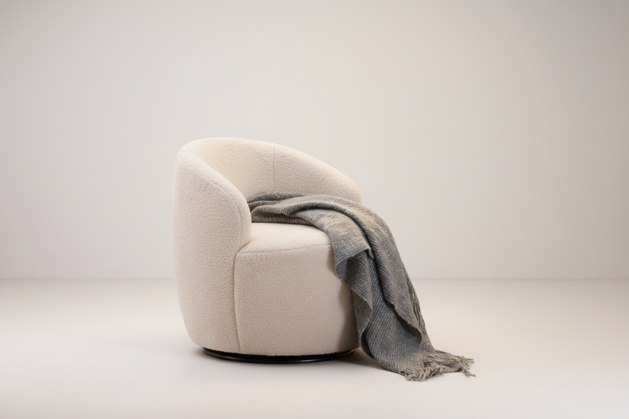 Beige armchair with a gray blanket draped over it on a white background