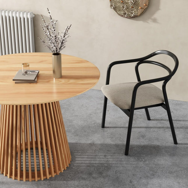 Wooden dining table with a vase of flowers and a black chair in a room.