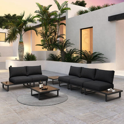 Modern outdoor furniture set with black sofas and wooden tables in a stylish patio setting.