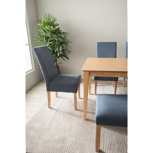 Dining room with blue chairs and a wooden table, featuring a plant in the background.
