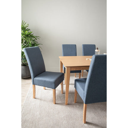 Dining room with blue chairs and a wooden table, featuring a plant in the background.