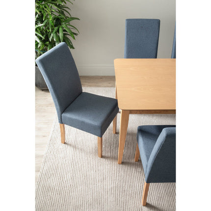 Blue chairs around a wooden dining table with a plant in the background