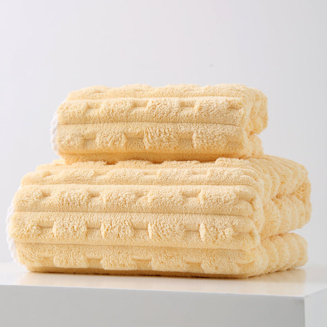 Stack of folded yellow towels on a white surface with a light gray background