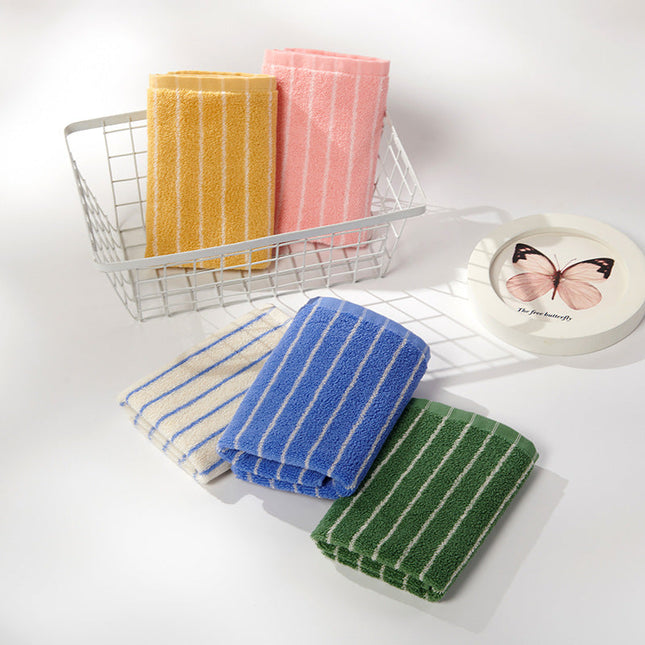Set of striped towels in yellow, pink, blue, and green on a white surface with a wire basket.
